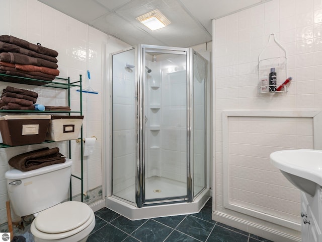 full bath featuring toilet, tile walls, and a stall shower