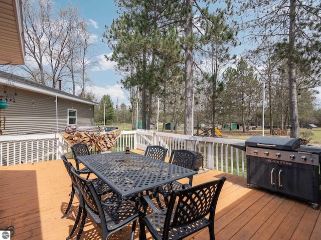 deck with outdoor dining area and grilling area