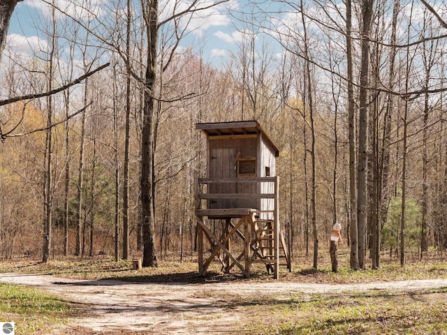 view of outbuilding featuring a forest view and an outdoor structure