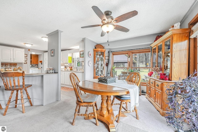 dining room featuring light colored carpet, a textured ceiling, and ceiling fan