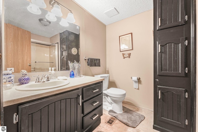 bathroom featuring vanity, visible vents, toilet, a textured ceiling, and tile patterned floors