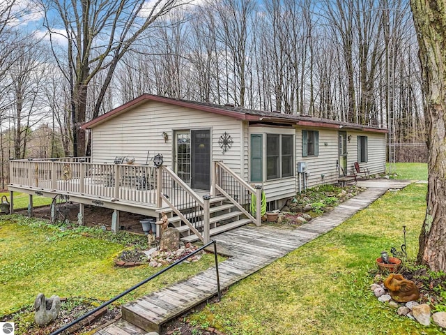 view of front of property featuring a wooden deck and a front yard