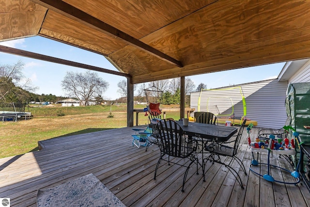 7276 Tiger Dr Unit A, And B, Lake Ann, MI 49650 - wooden terrace featuring outdoor dining area, a trampoline, and a lawn