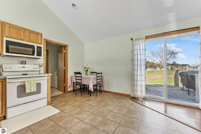 7276 Tiger Dr Unit A, And B, Lake Ann, MI 49650 - kitchen with light tile patterned floors, baseboards, high vaulted ceiling, light countertops, and white appliances