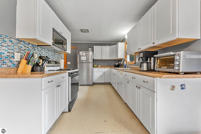 1981 S Lake Mitchell Dr, Cadillac, MI 49601 - kitchen featuring a toaster, white appliances, and white cabinetry