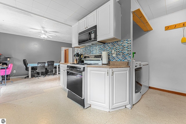 1981 S Lake Mitchell Dr, Cadillac, MI 49601 - kitchen with independent washer and dryer, black microwave, baseboards, backsplash, and range with electric stovetop