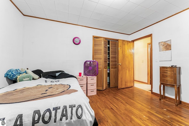 1981 S Lake Mitchell Dr, Cadillac, MI 49601 - bedroom with crown molding, wood-type flooring, baseboards, and a closet