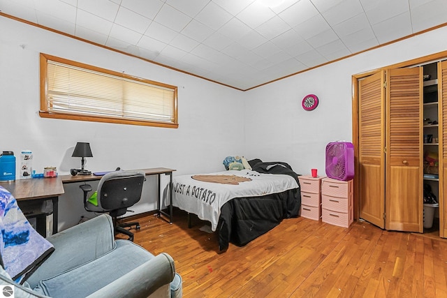 1981 S Lake Mitchell Dr, Cadillac, MI 49601 - bedroom featuring crown molding, a closet, and light wood finished floors