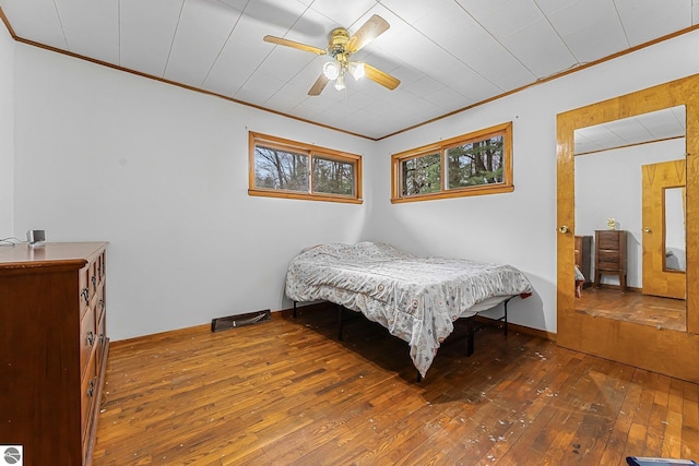 1981 S Lake Mitchell Dr, Cadillac, MI 49601 - bedroom with ornamental molding, ceiling fan, and hardwood / wood-style floors