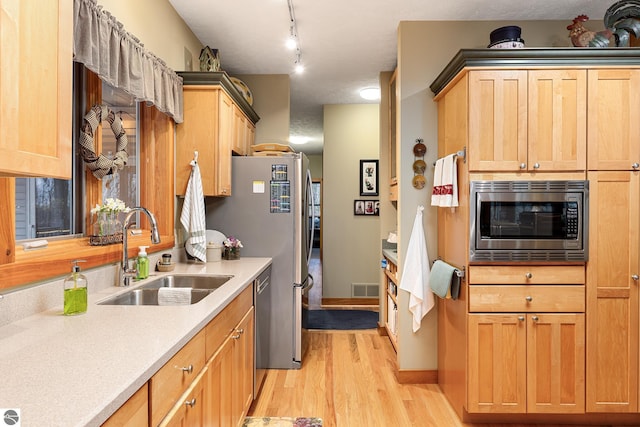 kitchen with visible vents, light wood-style floors, light countertops, a sink, and appliances with stainless steel finishes