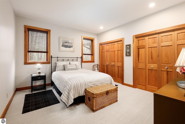 carpeted bedroom featuring multiple closets, baseboards, and recessed lighting
