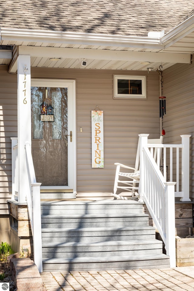 property entrance with a porch and a shingled roof