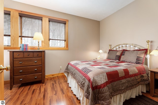 bedroom with baseboards and wood finished floors