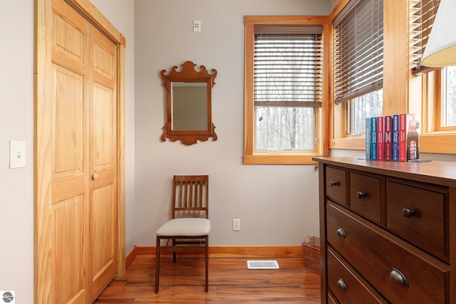 sitting room with baseboards, wood finished floors, and visible vents