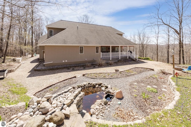 back of property featuring a shingled roof and covered porch