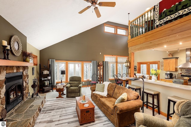 living room featuring a ceiling fan, high vaulted ceiling, and a fireplace