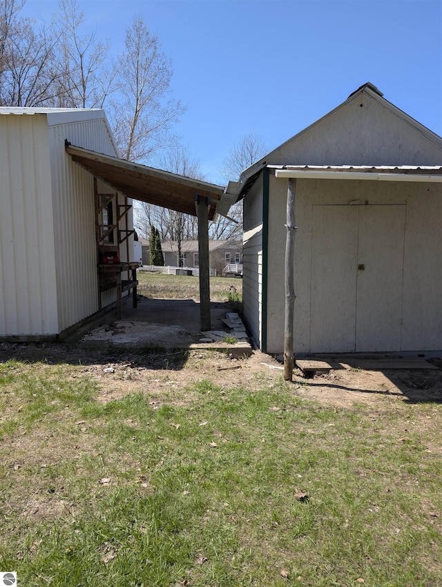 exterior space with a yard, an outdoor structure, and a carport