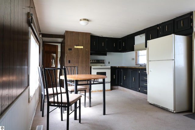 kitchen with white appliances, dark cabinets, visible vents, and under cabinet range hood
