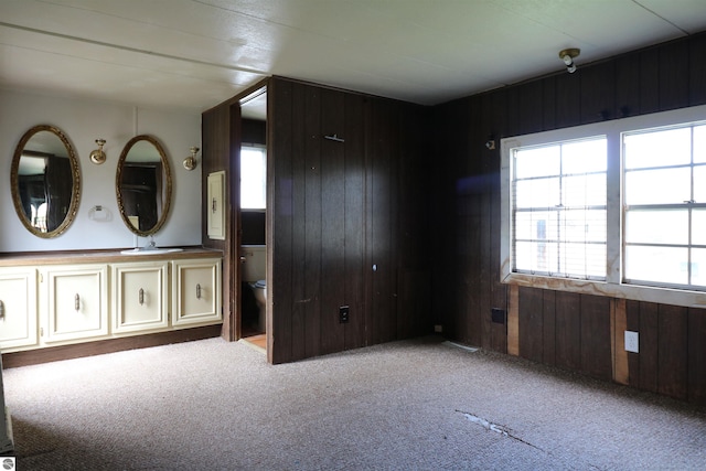 unfurnished bedroom featuring wood walls and carpet