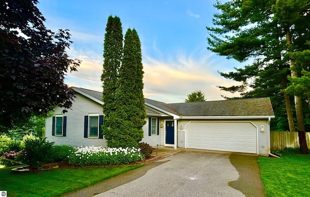 4215 Hearthside Dr, Traverse City, MI 49684 - single story home with an attached garage, fence, a front lawn, and aphalt driveway