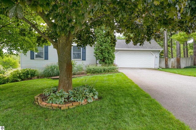 4215 Hearthside Dr, Traverse City, MI 49684 - view of property hidden behind natural elements with a front lawn, fence, and aphalt driveway