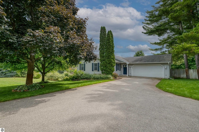 4215 Hearthside Dr, Traverse City, MI 49684 - single story home featuring an attached garage, fence, a front lawn, and aphalt driveway