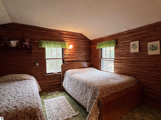 carpeted bedroom with lofted ceiling and rustic walls