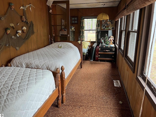 bedroom with multiple windows and wooden walls