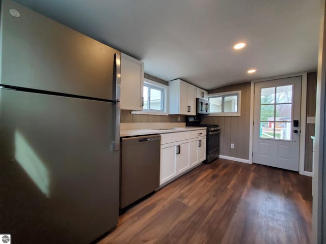 kitchen featuring stainless steel appliances, light countertops, dark wood-style floors, and white cabinets