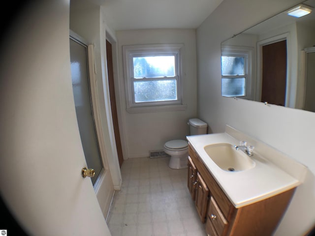 full bathroom with tile patterned floors, a shower with door, toilet, vanity, and baseboards