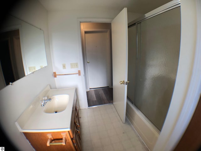 bathroom with tile patterned floors, vanity, and bath / shower combo with glass door