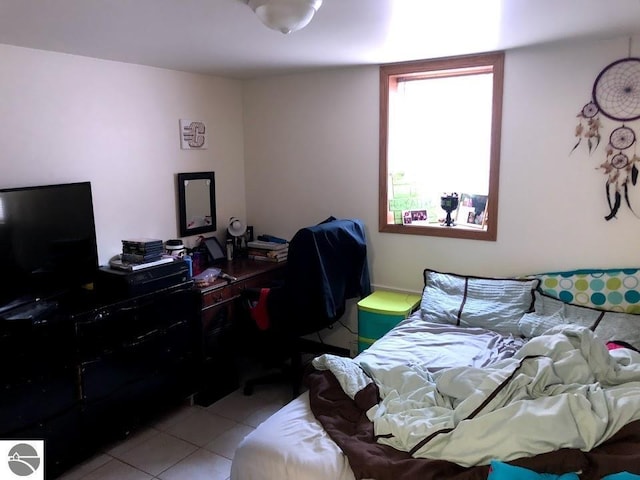 bedroom featuring light tile patterned floors and a desk