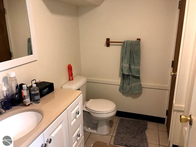 half bathroom featuring tile patterned flooring, vanity, and toilet