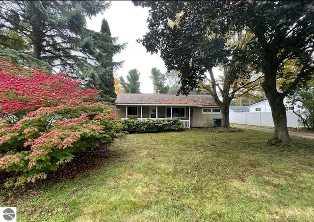 12805 S Sylvia St, Traverse City, MI 49684 - exterior space featuring a front yard, a porch, and fence