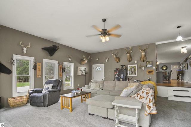 carpeted living room with ceiling fan