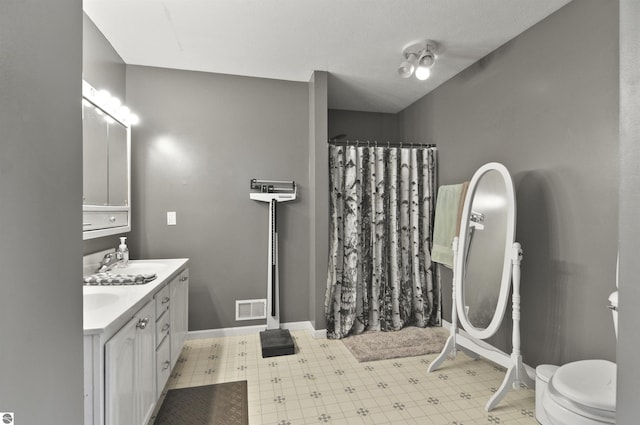 full bath featuring a sink, toilet, a shower with curtain, visible vents, and tile patterned floors