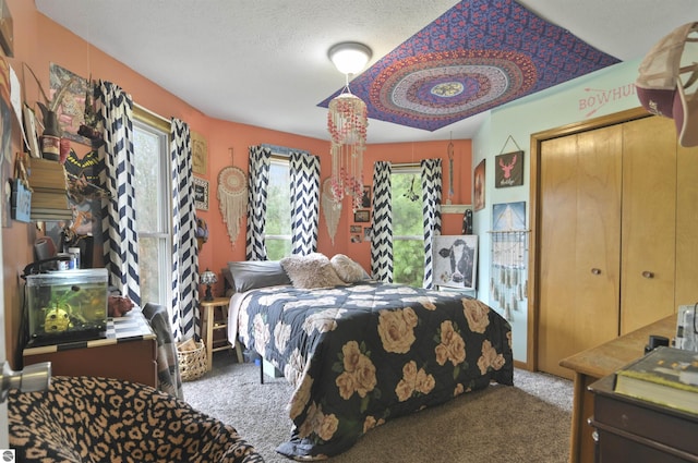 bedroom featuring a textured ceiling and carpet flooring