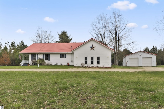 single story home featuring a front lawn, metal roof, an outbuilding, and a garage