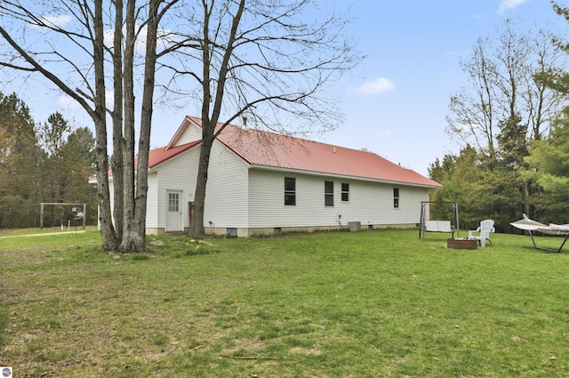 rear view of house with a lawn and metal roof