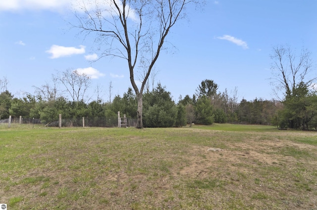 view of yard featuring a forest view and fence