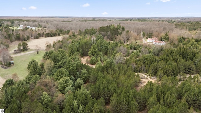 drone / aerial view featuring a wooded view
