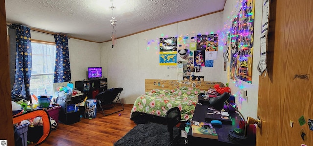 bedroom with crown molding, a textured ceiling, and wood finished floors