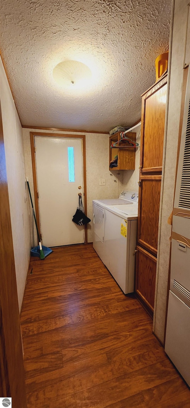 laundry room featuring a textured ceiling, independent washer and dryer, and wood finished floors