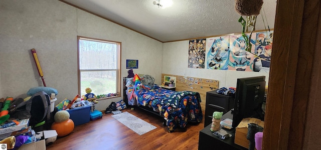 bedroom featuring lofted ceiling, a textured ceiling, and wood finished floors