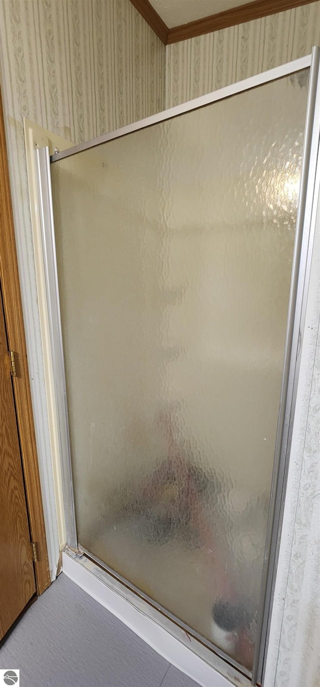 bathroom featuring a shower stall and crown molding