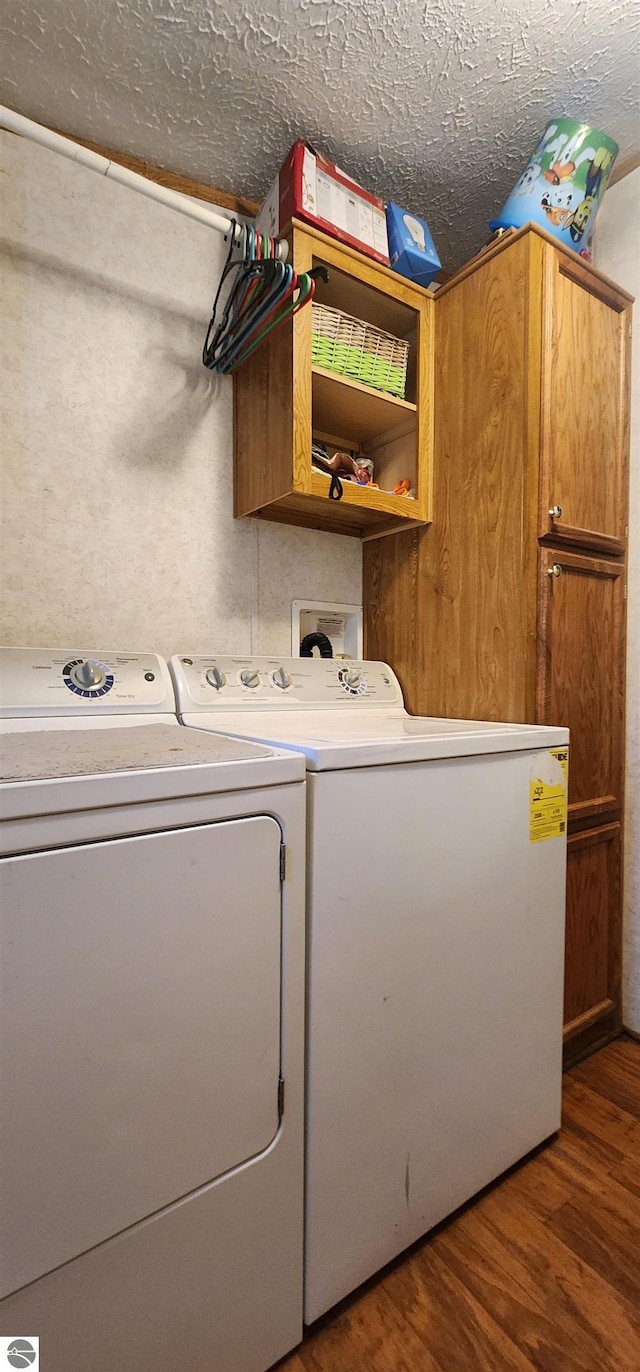laundry room with washer and dryer, cabinet space, and wood finished floors