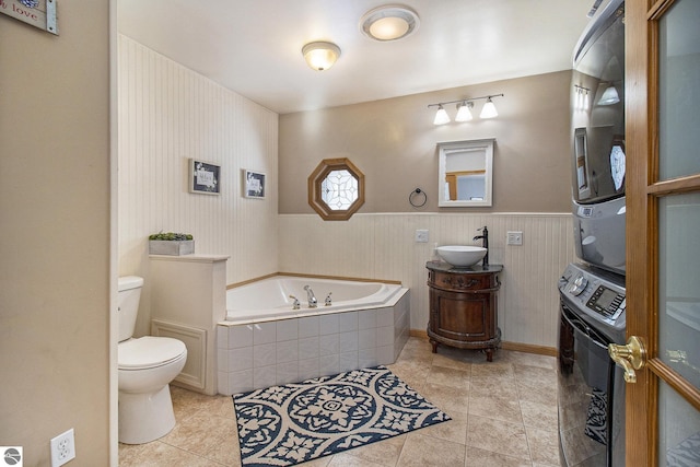 7809 Potter Rd, Bear Lake, MI 49614 - full bath with stacked washer and clothes dryer, a garden tub, toilet, and tile patterned flooring