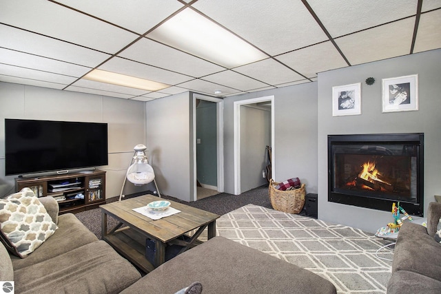 7809 Potter Rd, Bear Lake, MI 49614 - living area featuring carpet, a drop ceiling, and a warm lit fireplace