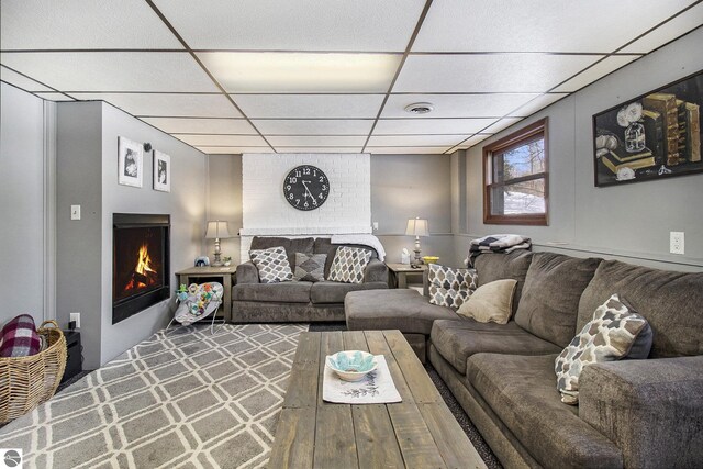 7809 Potter Rd, Bear Lake, MI 49614 - living room with a paneled ceiling, a lit fireplace, and visible vents
