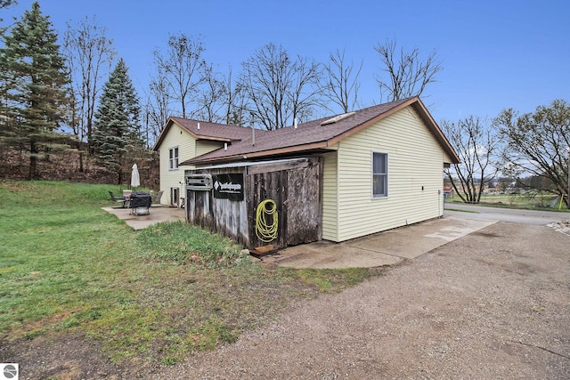 7809 Potter Rd, Bear Lake, MI 49614 - view of property exterior with a shingled roof, a patio area, and a lawn